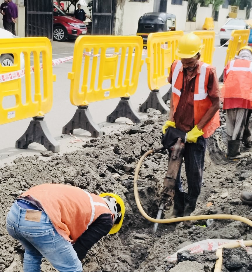 Crew manually trenching and clearing debris for duct installation